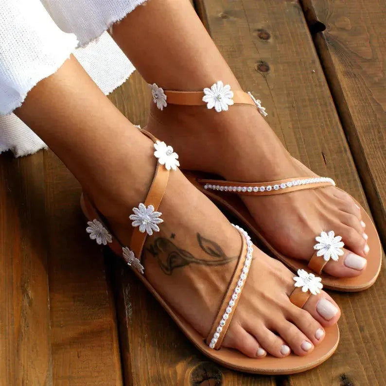 Brown women's flat Roman sandals with floral pattern on the artificial PU upper.