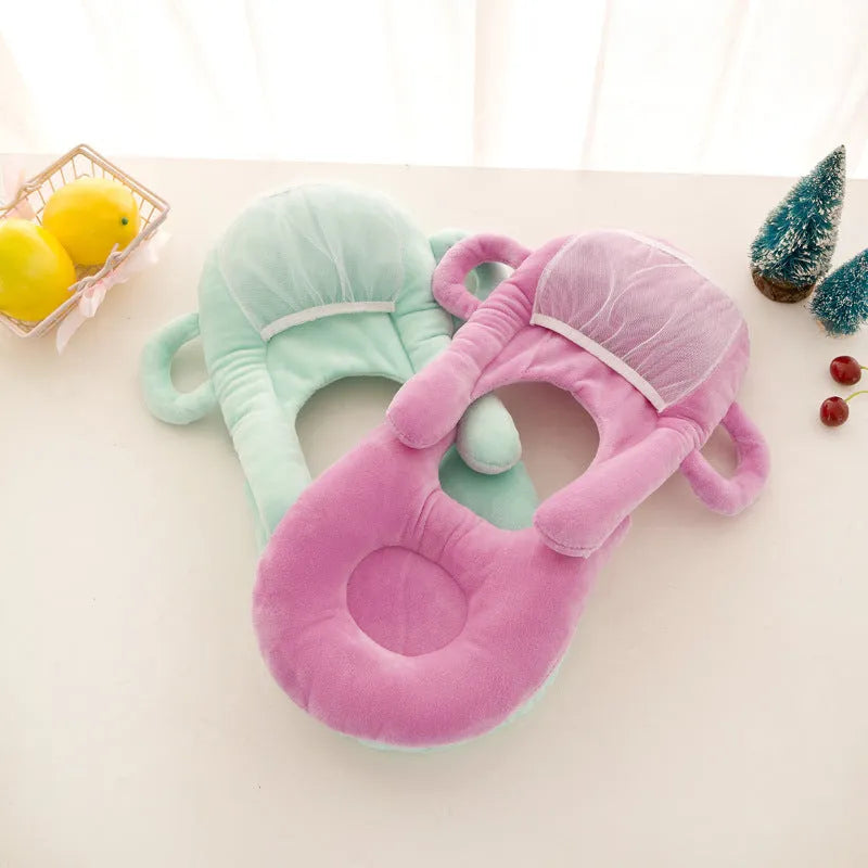Pink plush baby feeding pillow on a carpet, showing its 30cm by 42cm size and soft texture.