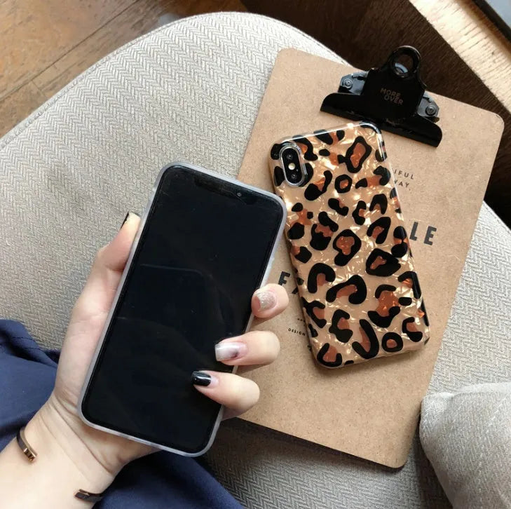Colourful leopard print silicone TPU phone case for iPhone models on a table.