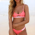 Women's black and white dot bikini set and red and white stripe bikini set laid flat.