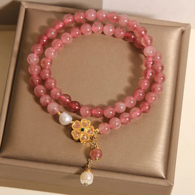 Women's twin four-leaf clover charm bracelet with strawberry quartz crystals and alloy inlay settings.