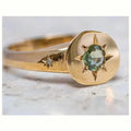 Gold coloured adjustable ring with a star-shaped zircon stone set via micro-inlay on a simple oval band.
