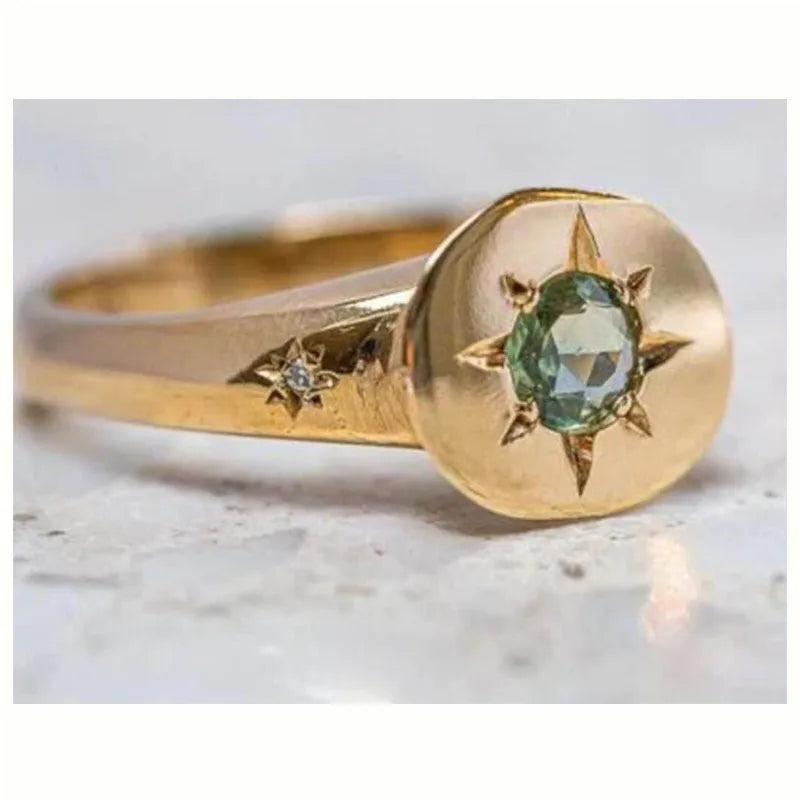 Gold coloured adjustable ring with a star-shaped zircon stone set via micro-inlay on a simple oval band.