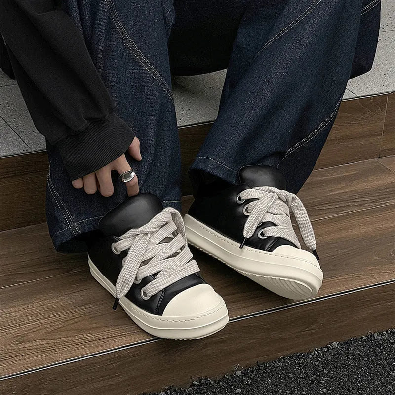 Men's black slip-on casual shoes with raised sole, leather uppers, and rubber soles showing round toe and shallow cut design