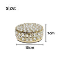 Crystal clear glass jewelry box with French gold metal frame on a table.
