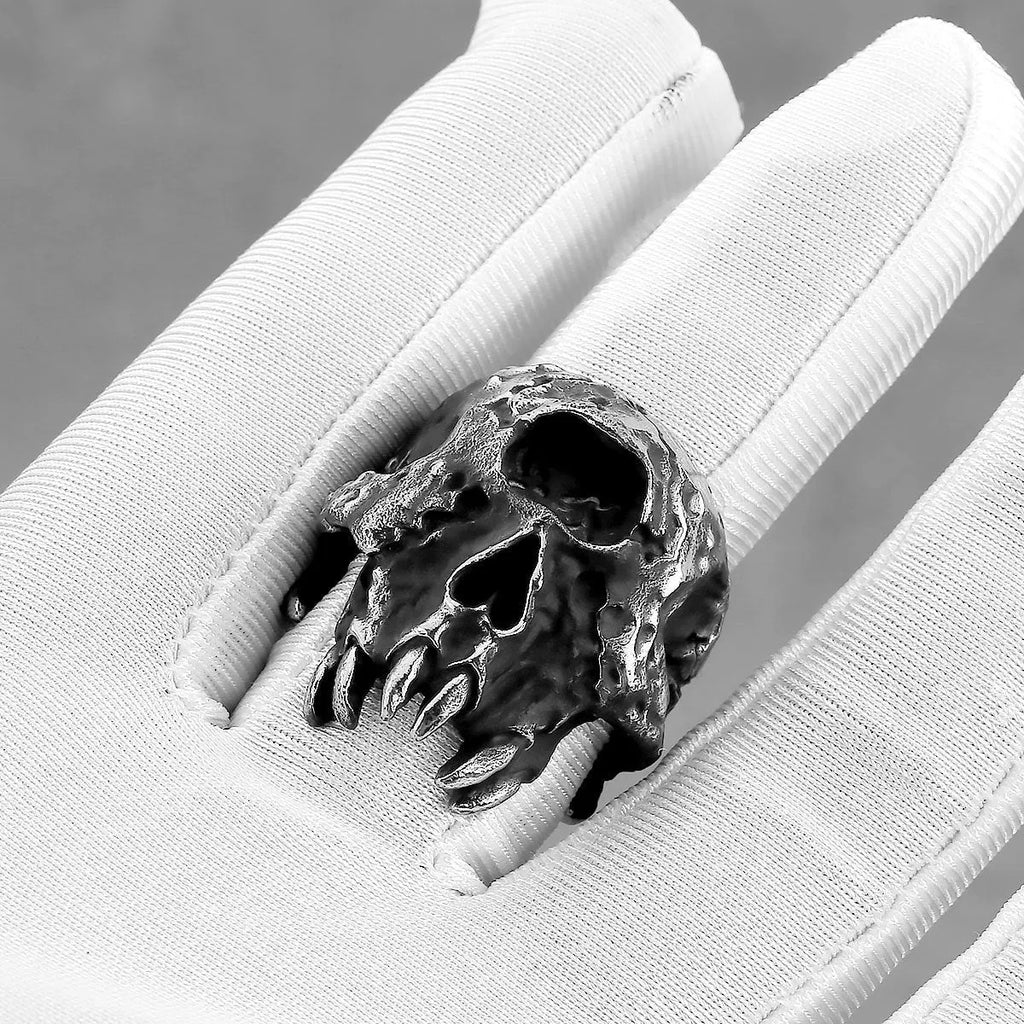 Close-up of a silver-toned alloy ring with a detailed one-eyed skull design on a finger.