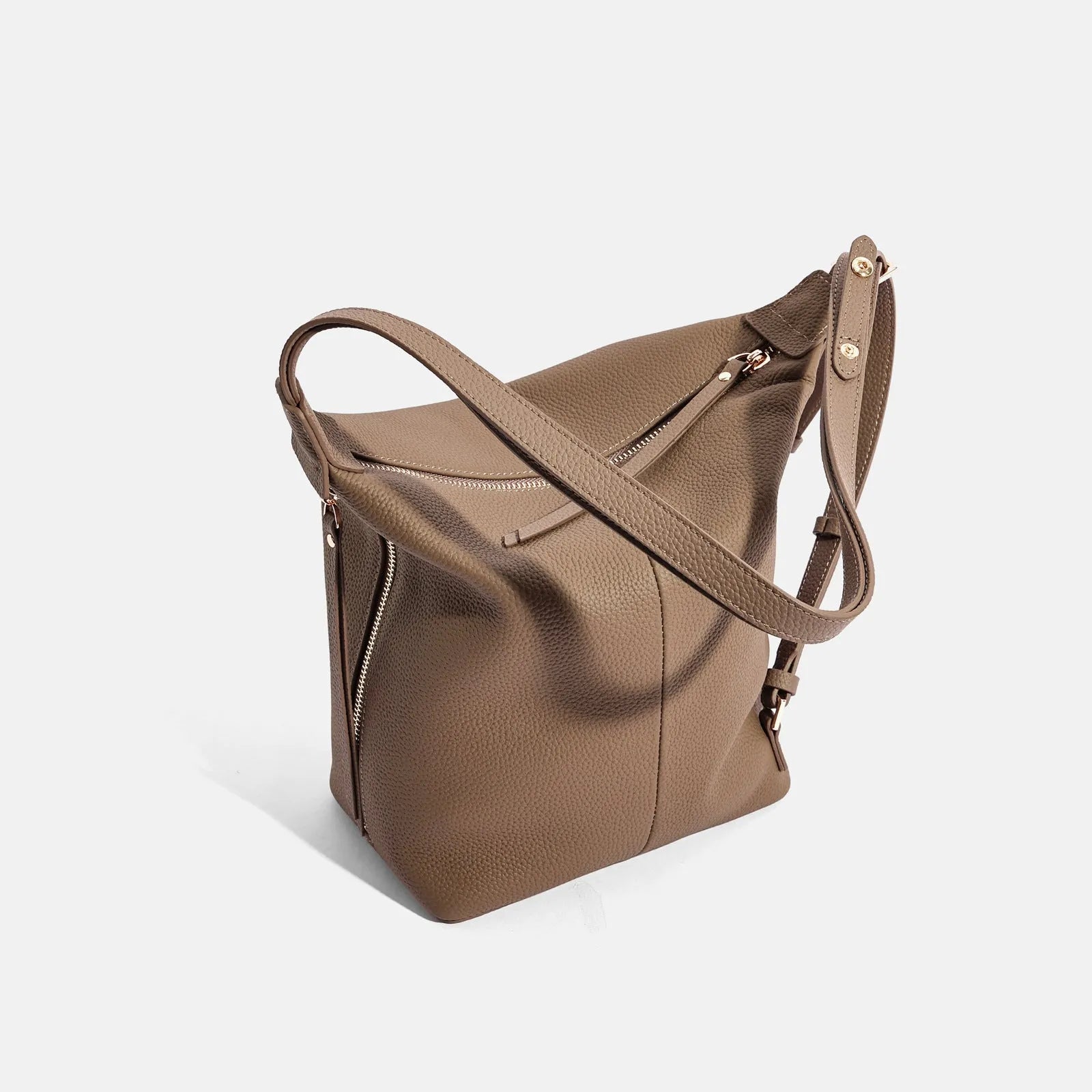 Women's large grey genuine leather bucket bag with a soft handle on a casual outfit.