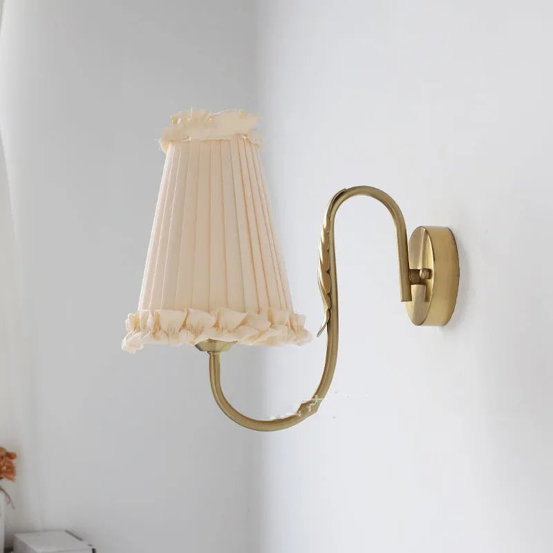 Wheat wall lamp with fabric shade and iron frame mounted on a bedroom wall with warm non-stroboscopic light