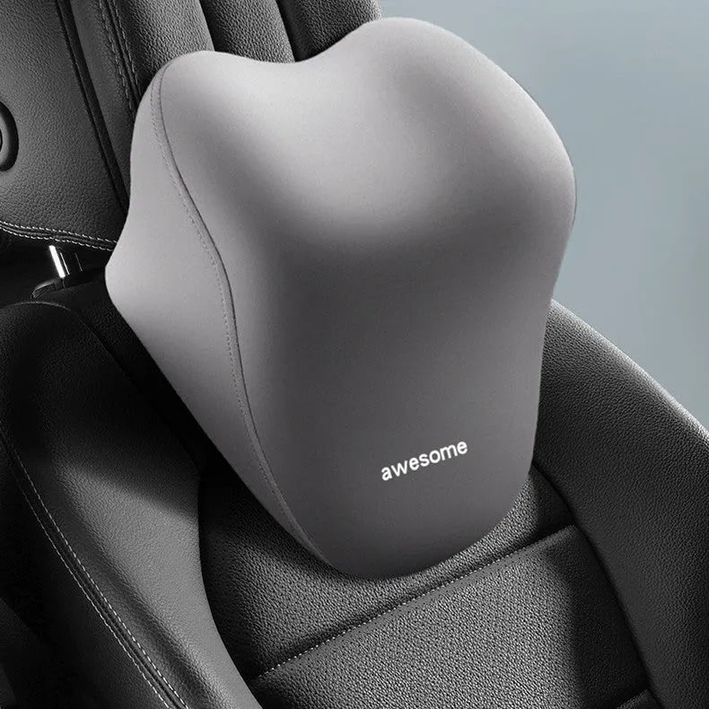 Black and beige memory foam car headrest pillow and lumbar support cushion on a vehicle seat.