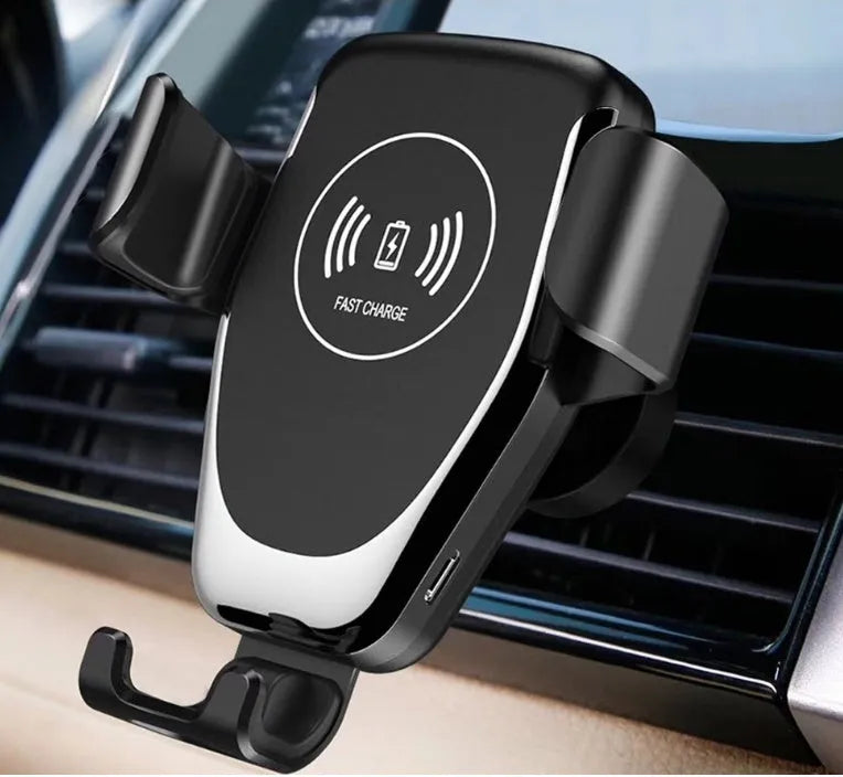 Black car wireless charger with automatic arms, mounted on a car air vent, charging an iPhone.
