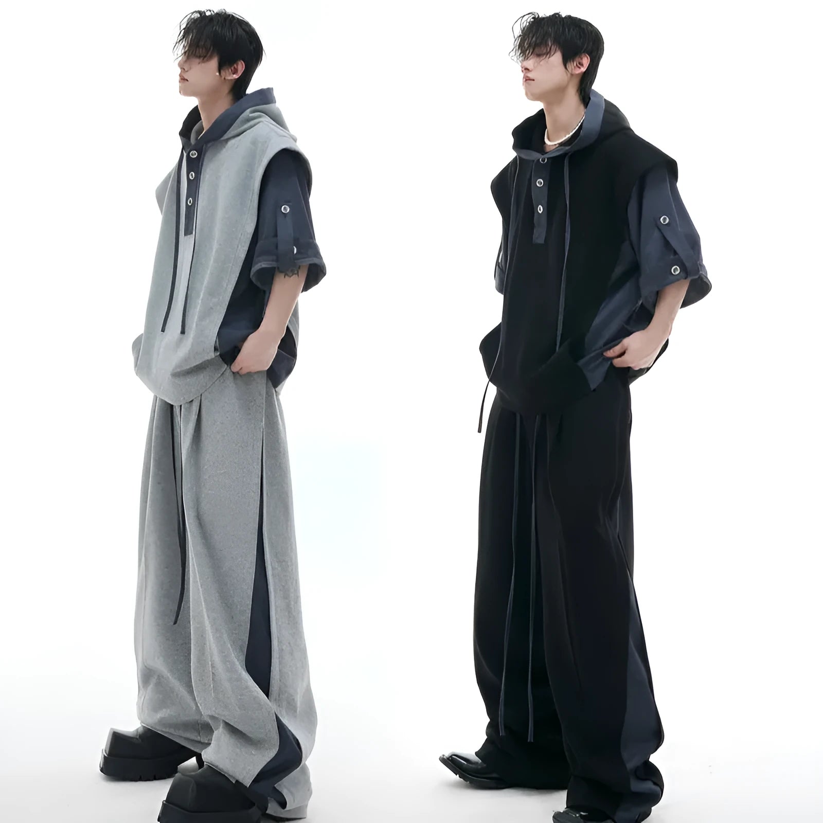 Man wearing a black hooded short sleeve sports jacket with textured stitching and matching full-length trousers.