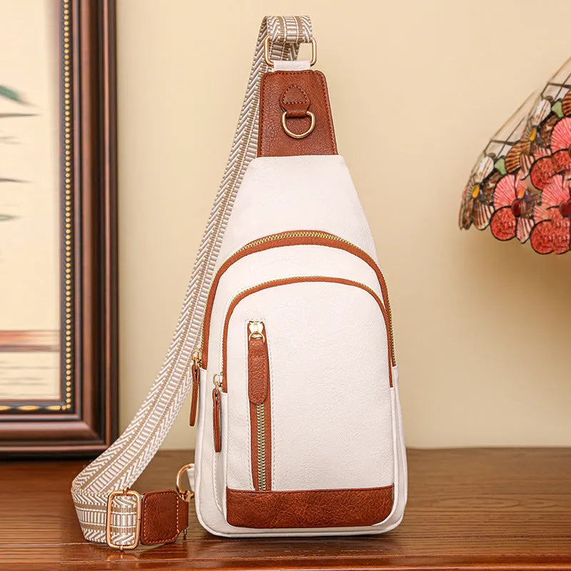 Soft brown women's crossbody chest bag with an open front pocket and decorative stitching.