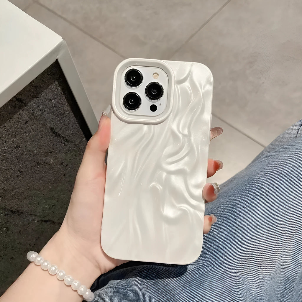 Milky white silicone iPhone case with a water ripple texture on a table.