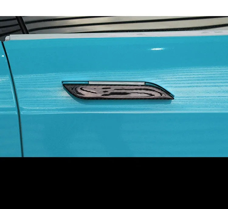 Four black carbon fibre pattern adhesive door handle protectors for a Tesla Model S.