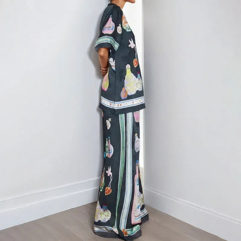 Black women's casual set with cartoon print, featuring a cardigan and matching trousers on a hanger.