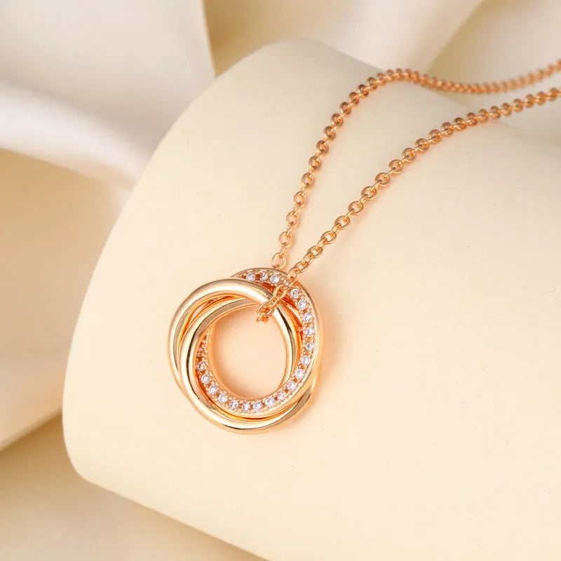 Geometric copper necklace with micro-inlaid interlocking three rings in champagne gold on woman
