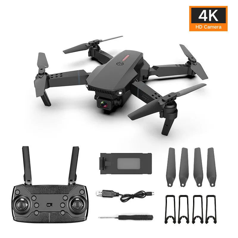 Grey foldable 4K dual camera drone with remote control, spare blades, and charging cable on a neutral background.