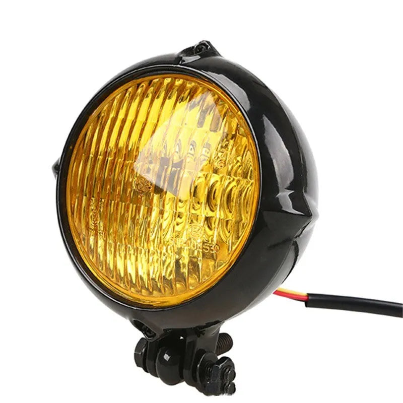 Black circular aluminium Harley-style motorcycle headlight with a coloured glass lens.