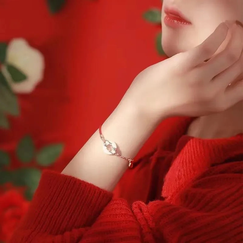 Close-up of a red rope festive koi bracelet for women with a peace buckle and fish tail details.