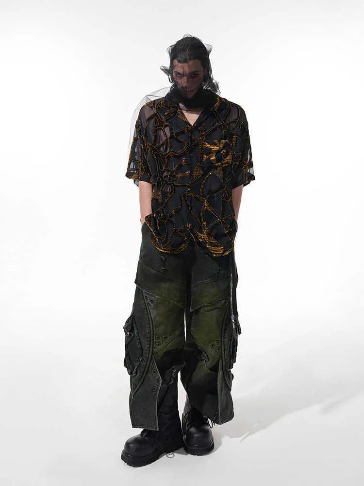 Man wearing a loose-fit black short-sleeved shirt with a translucent snake pattern print and lapel collar.