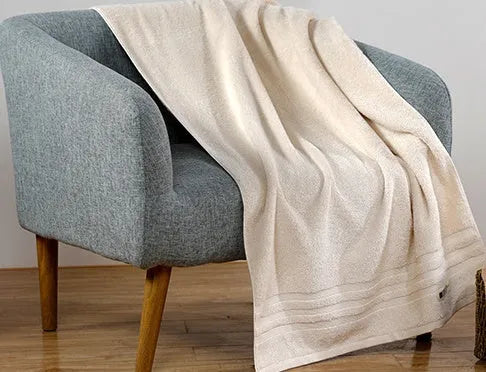 Set of three cotton towels in beige and brown colours, showing small, medium, and large sizes.