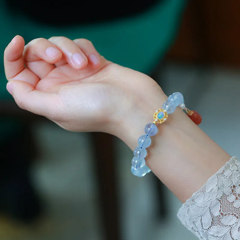 DIY kit components for an aquamarine fox Fengjiu bracelet with pearl and pink crystal beads.