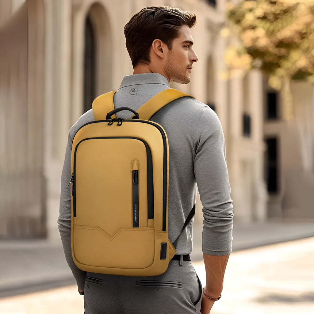 Lightweight solid-colour polyester laptop backpack showing external USB charging port.
