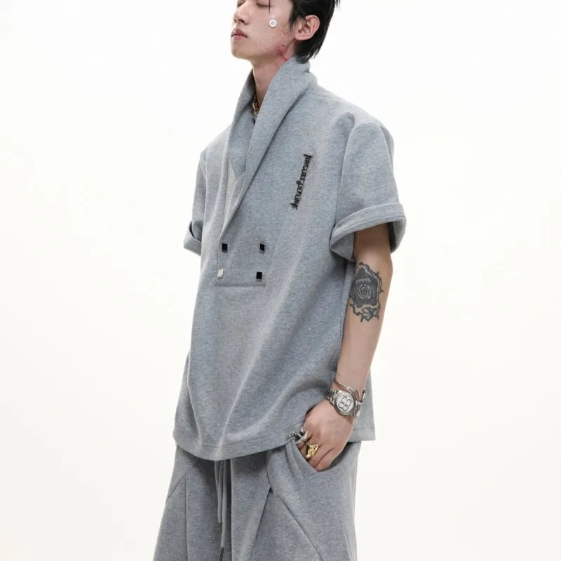 Men's dark grey V-neck cotton sports jacket with padded shoulders and metal trim, paired with matching shorts.