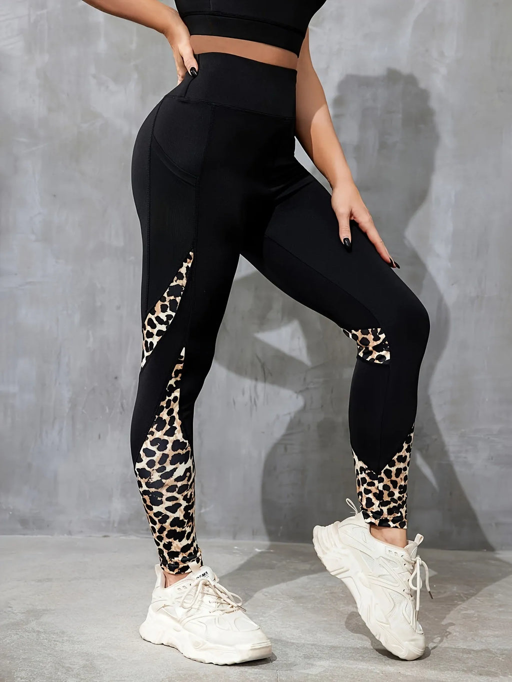 Black women's high-waist fitness leggings with colour-contrast patchwork patterns and side pockets.