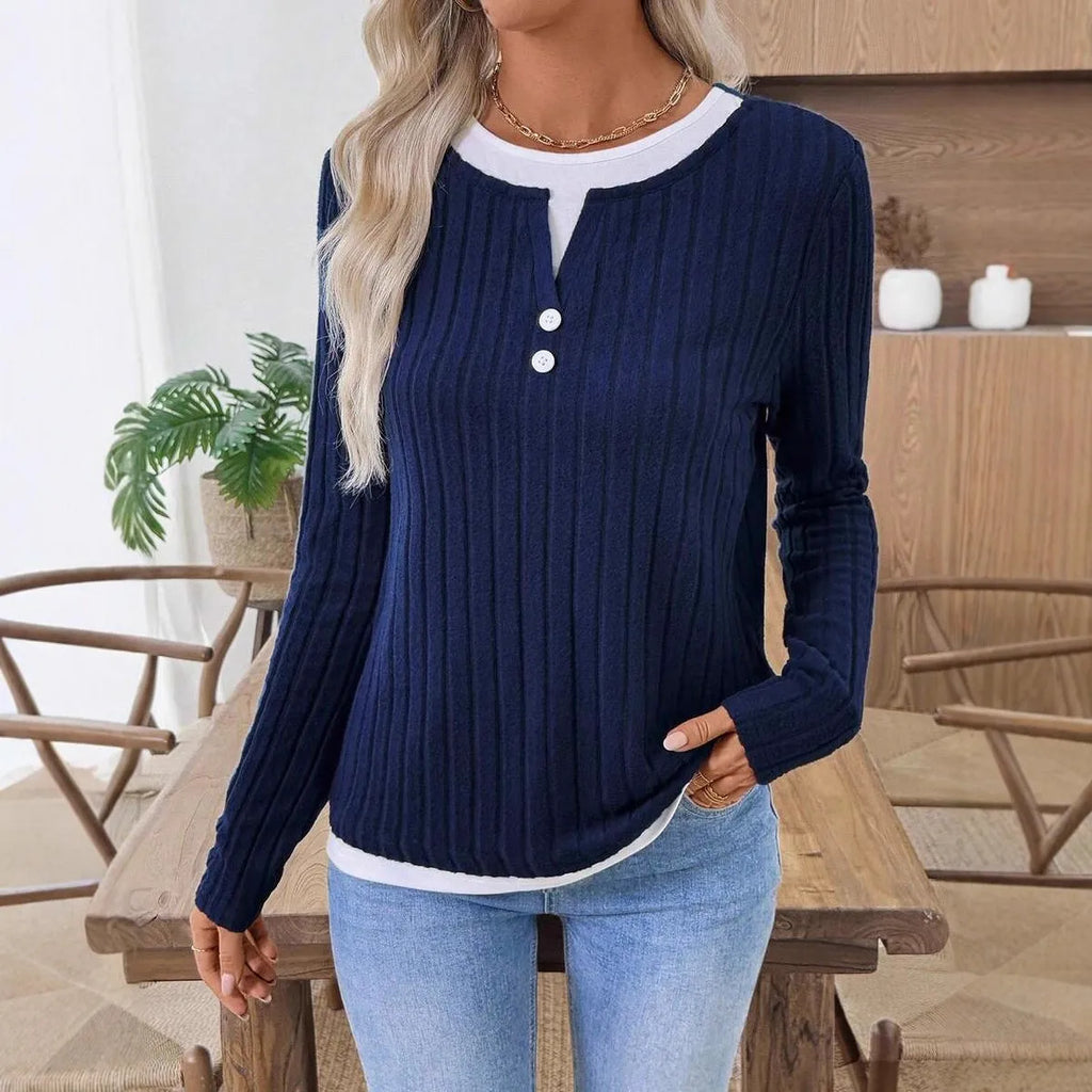 Women's black fake two-piece pullover sweater with round neck, button, and long sleeves on a hanger.
