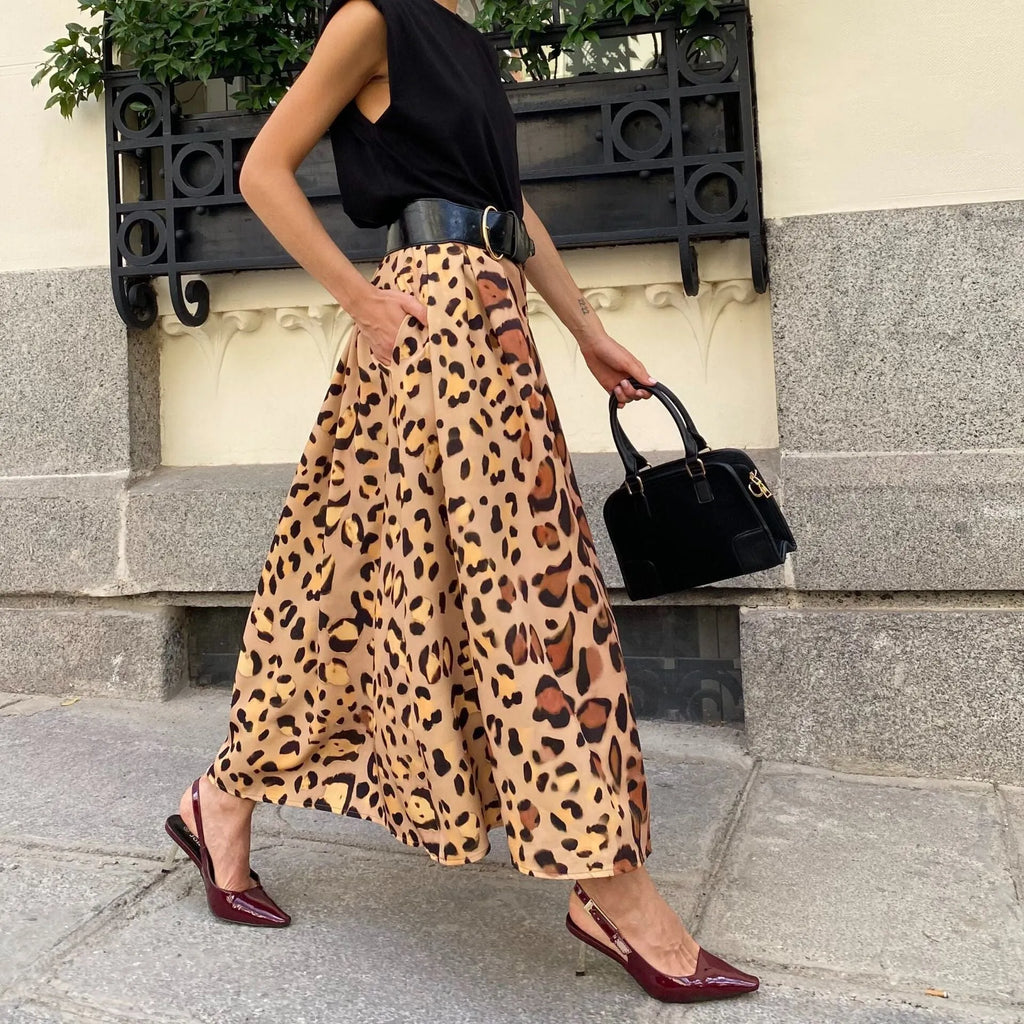 Brown leopard print women's long A-line skirt with a defined waist and wide, flowing hem on a neutral background.
