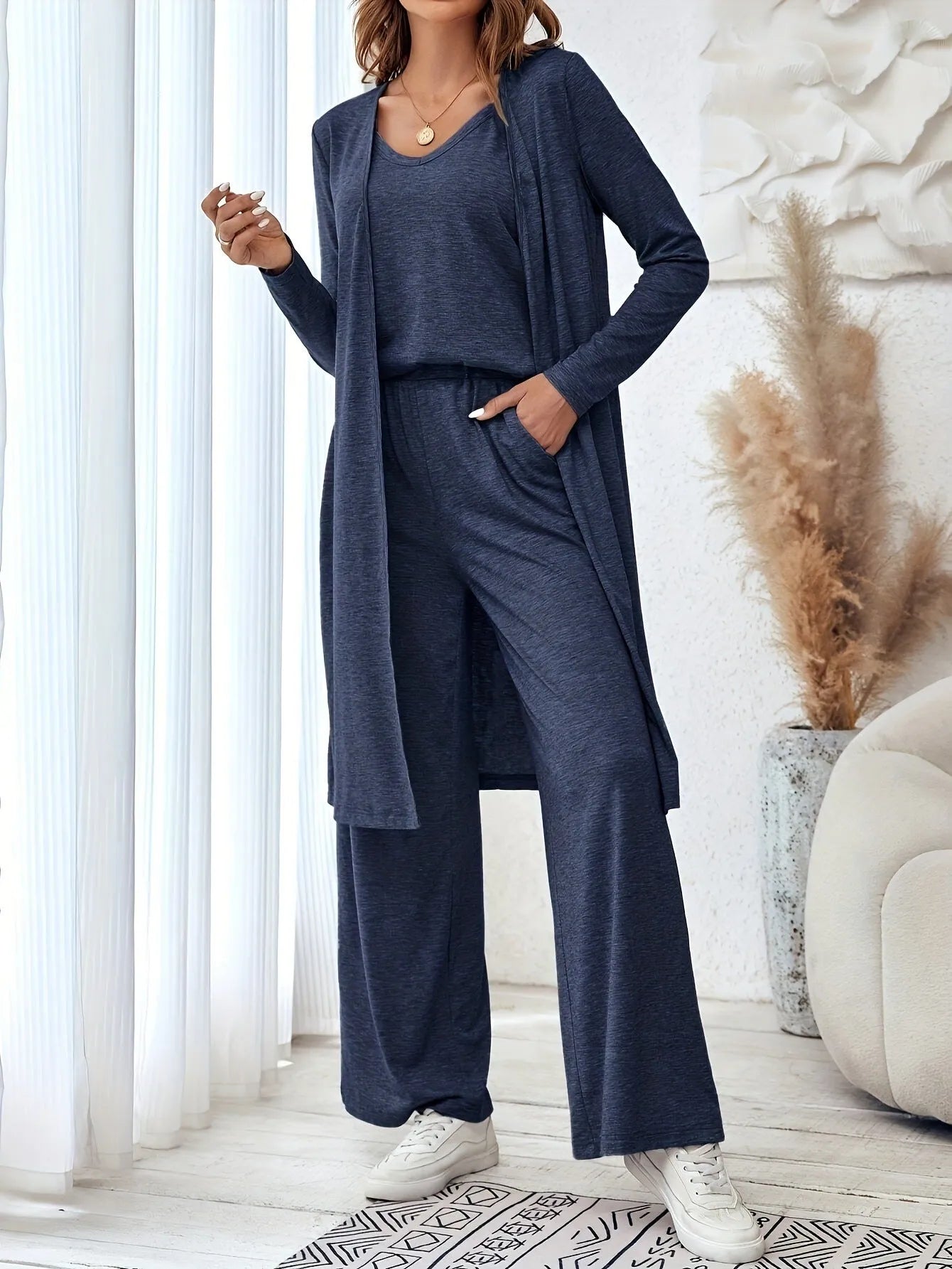 Blue women's casual two-piece suit with top, trousers, and black suspenders laid flat.