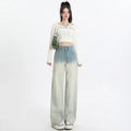 Women's gradient blue wide-leg denim trousers on a neutral background.