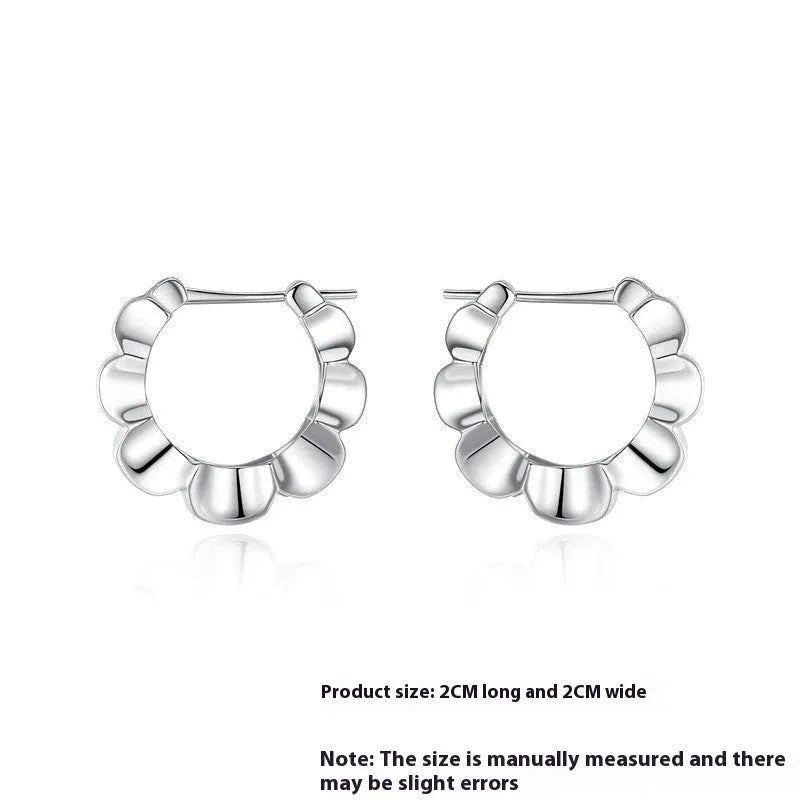 A pair of sterling silver geometric earrings with round accents on a white background.