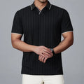 Man wearing a black loose-fit short-sleeved nylon polo shirt on a casual background.