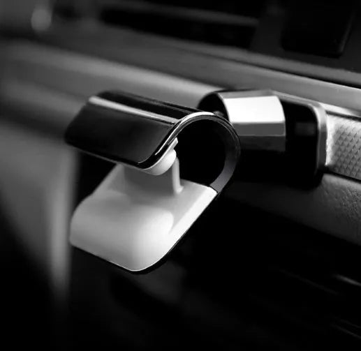 Black universal car phone holder with 360-degree rotation on dashboard