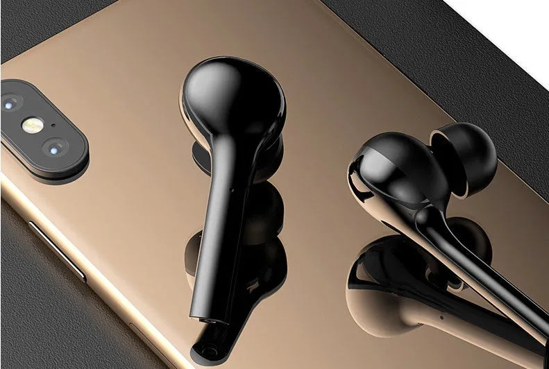 Black and white wireless touch control earbuds with a charging case on a table.