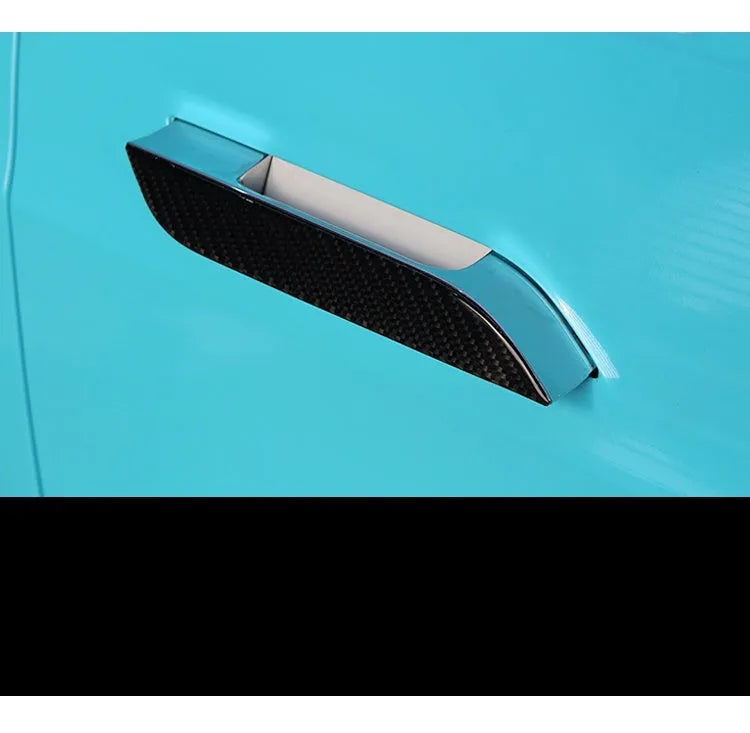 Four black carbon fibre pattern adhesive door handle protectors for a Tesla Model S.