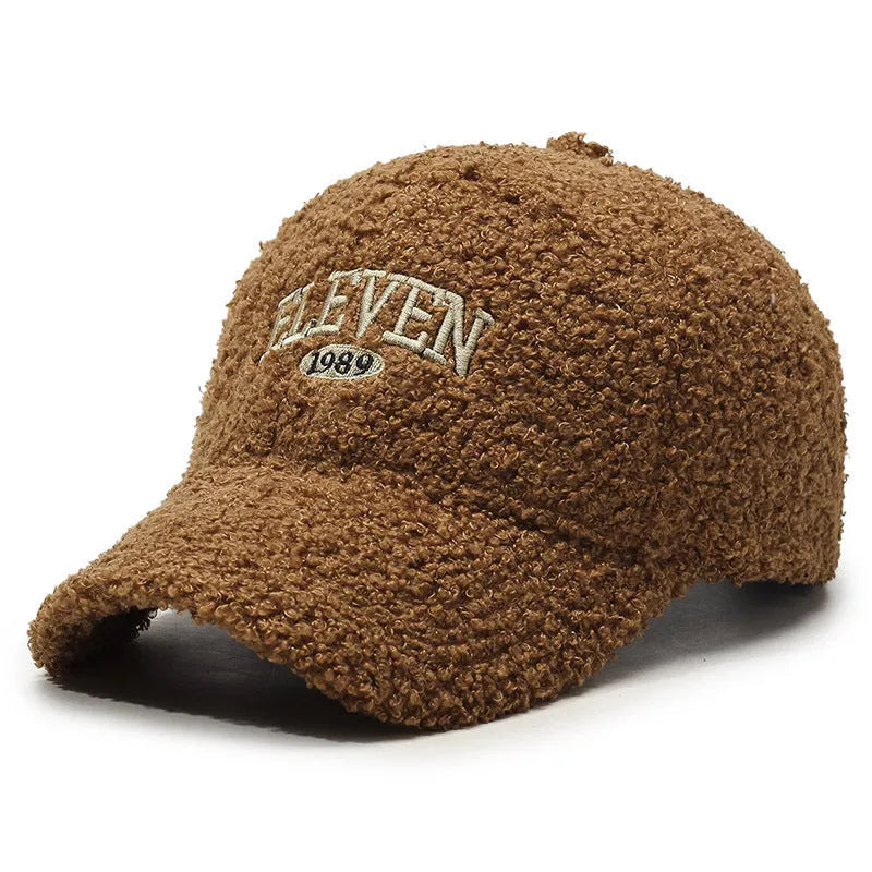 Adjustable lambskin winter baseball cap in black with dome crown and machine embroidery detail.