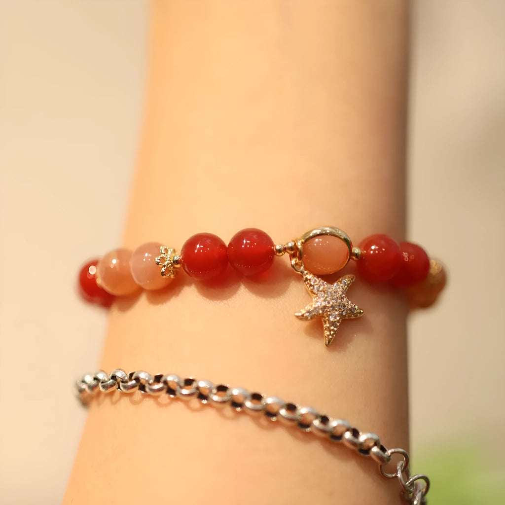 Handmade red agate bracelet with 8mm beads, star and xiangyun patterns, on a wrist.