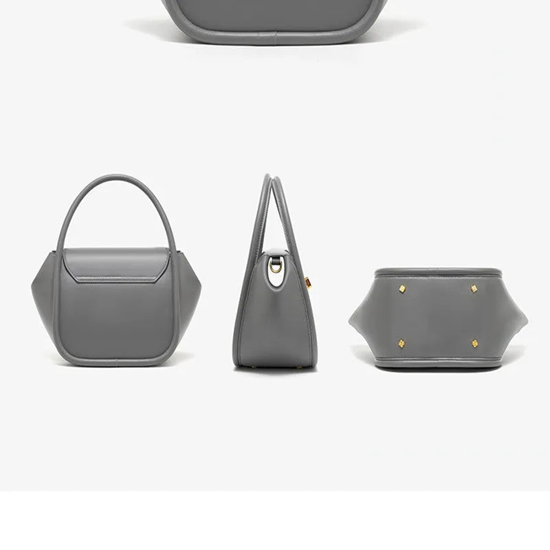 A women's leather wing-shaped tote bag with a metal latch, shown in blue on a cross-body strap.