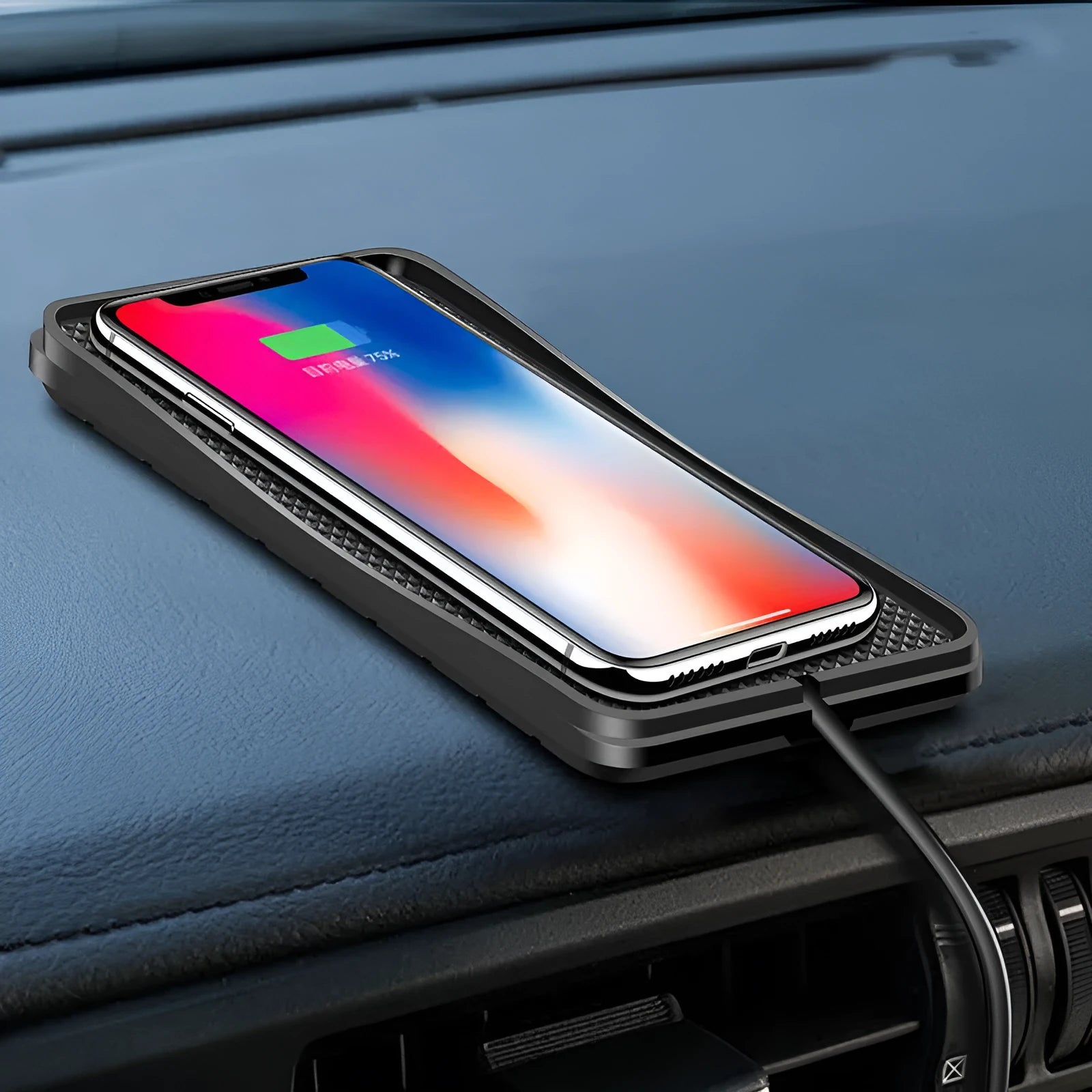 Black wireless car charger with anti-slip base, shown on a car dashboard next to a mobile phone.