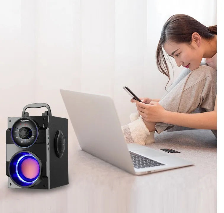 Compact black portable audio system with subwoofer, connection cable, and USB power input.
