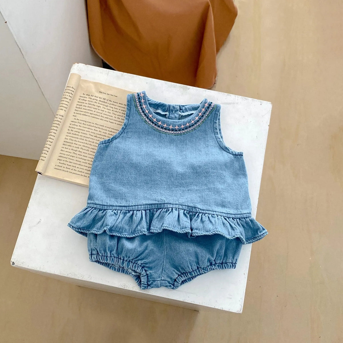 Baby girl denim cotton sleeveless two-piece suit with shorts on a white background