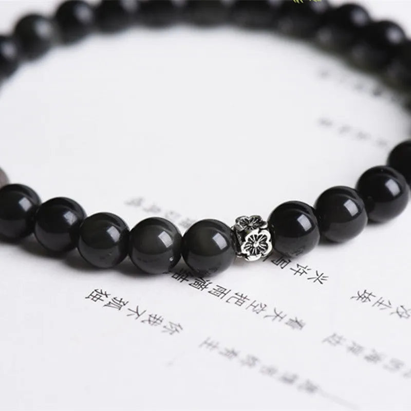 Natural obsidian beaded bracelet with S925 silver flower charms and dragon phoenix constellation design.