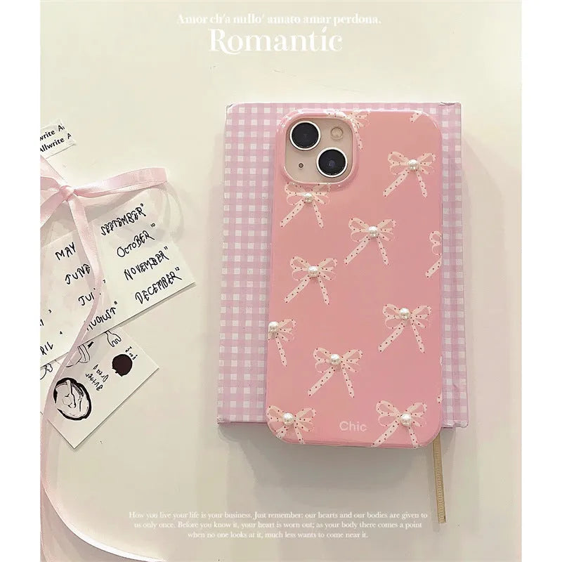 Pink soft TPU iPhone case with three-dimensional pearl dot bow, compatible with iPhone 11 to 15 Pro Max.