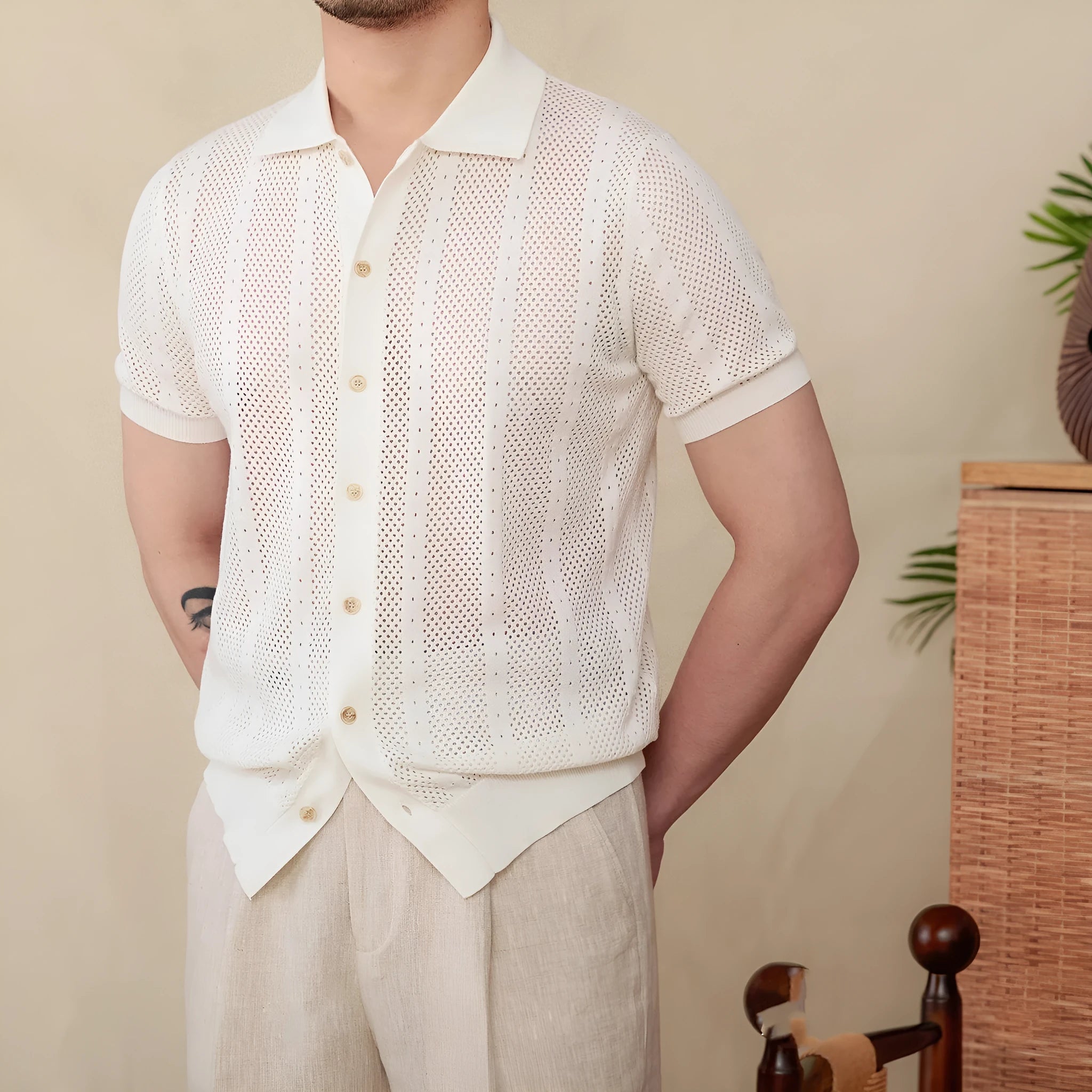 Man wearing a beige striped short sleeve cotton cardigan shirt with a lapel collar.