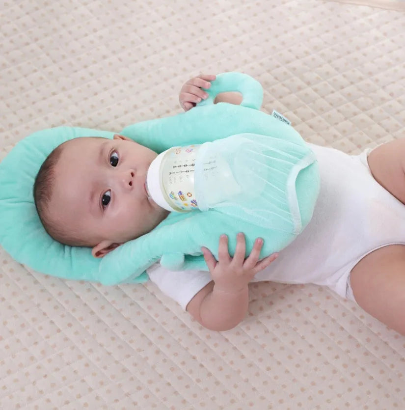 Pink plush baby feeding pillow on a carpet, showing its 30cm by 42cm size and soft texture.