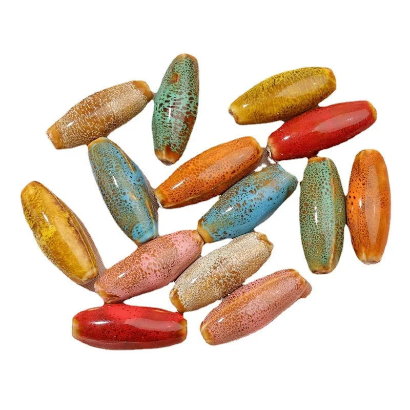 Assortment of ceramic bullet beads in pink, yellow, blue, red, coffee, green, orange, and mixed flower glaze colours.