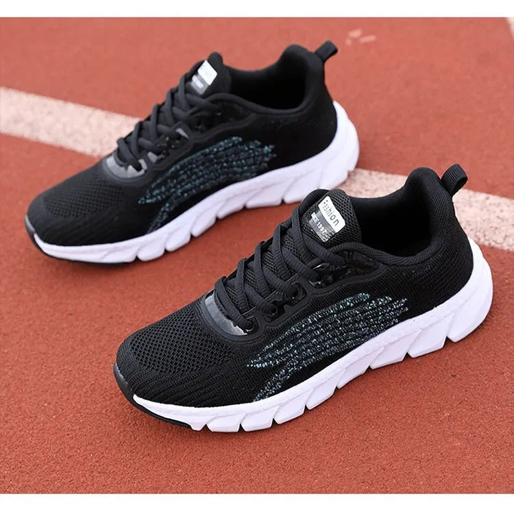 Low-top black and white running sneaker with cross strap and round toe on MD sole.